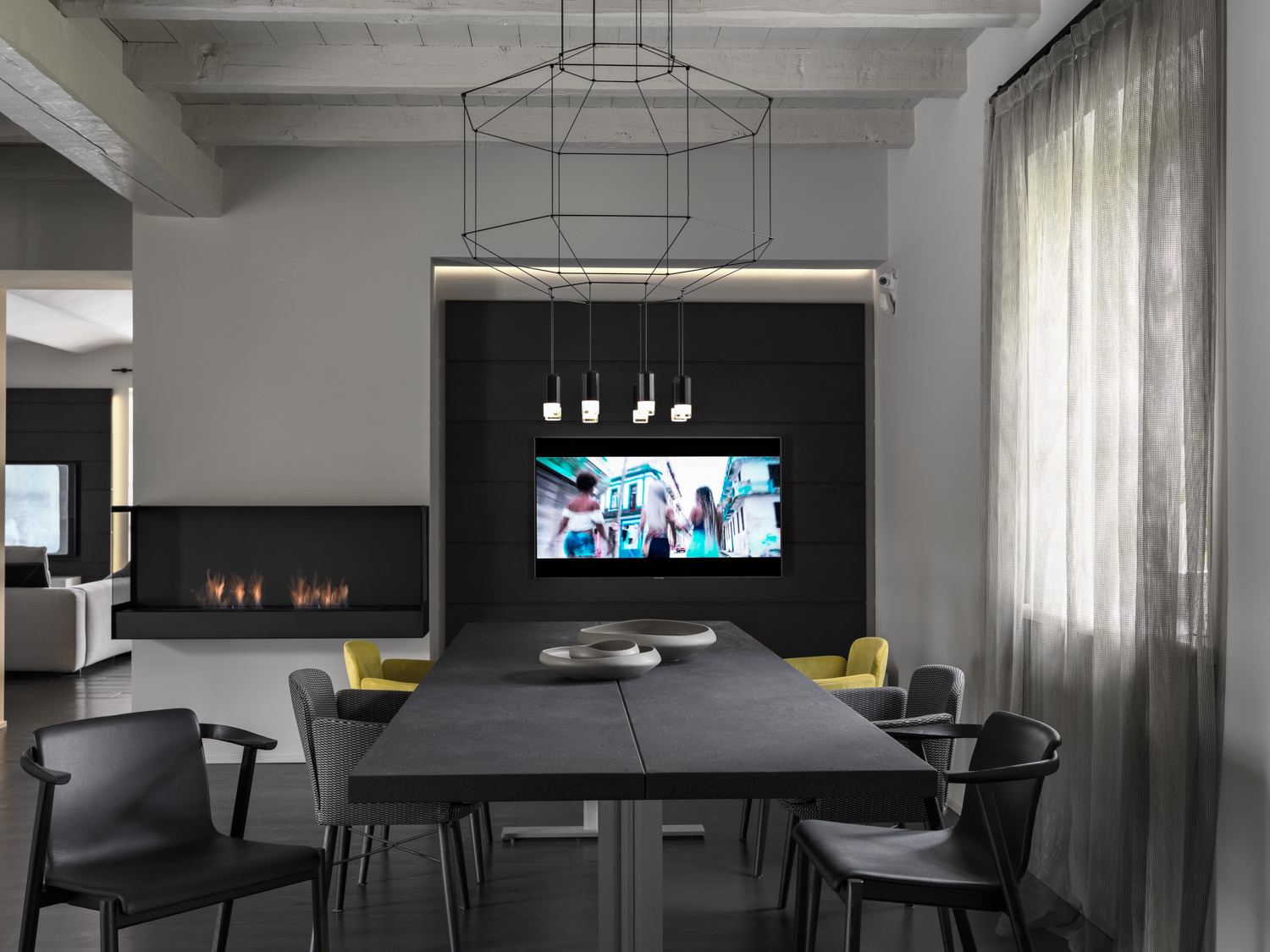 Sala da pranzo moderna con camino e tv